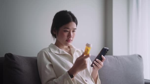 Mujer Asiática Enferma Sosteniendo Frasco Pastillas Leyendo Información Instrucciones Etiqueta — Vídeo de stock