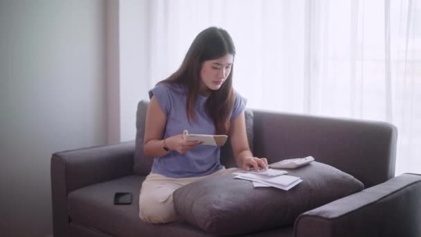 Junge Asiatinnen Sitzen Mit Einem Taschenrechner Auf Dem Sofa Einkommen — Stockvideo