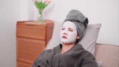 An Asian woman is applying a face mask for a rejuvenating skincare routine, nurturing her skins health and radiance at her home. Capture the essence of self-care and wellness