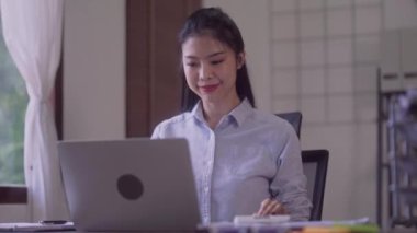 Young Asian entrepreneur woman counting calculations profit data on calculator at laptop computer, Startup business financial and economy concept. High quality 4k footage