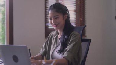 Young Asian Women Graphic designer Artist work on computer laptop and with graphic interactive drawing pen sitting in front of window at desk in office. High quality 4k footage