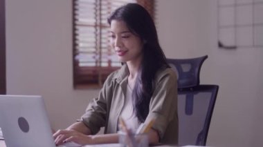 Young Asian woman Artist Creative Designer working on Laptop Computer to Creating Her Own Project in modern office. High quality 4k footage