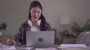 Young Asian Women Graphic designer Artist work on computer laptop and with graphic interactive drawing pen sitting in front of window at desk in office. High quality 4k footage