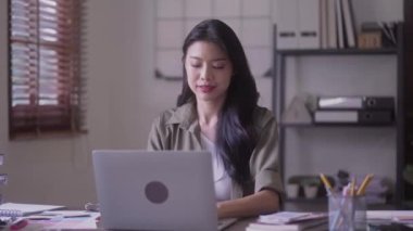 Young Asian woman Artist Creative Designer working on Laptop Computer to Creating Her Own Project in modern office. High quality 4k footage