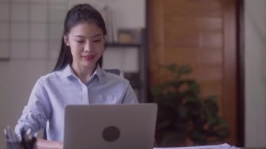 Young Successful Asian Businesswoman Sitting at Desk Working on Laptop Computer Woman working with Big Data e-Commerce in office. High quality 4k footage