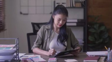 Young Asian Graphic designer woman with digitized a stylus pen drawing illustration on graphics tablet at home. High quality 4k footage