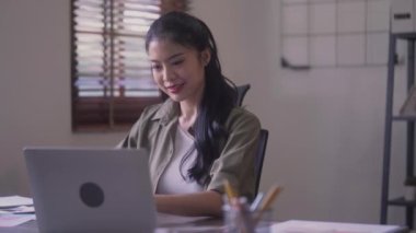 Young Asian woman Artist Creative Designer working on Laptop Computer to Creating Her Own Project in modern office. High quality 4k footage