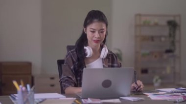 Young Asian Women Graphic designer Artist work on computer laptop and with graphic interactive drawing pen sitting in front of window at desk in office. High quality 4k footage