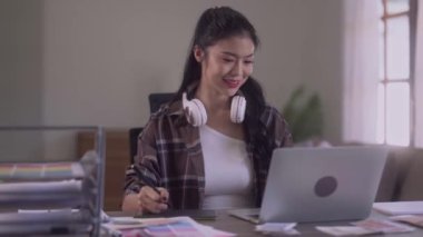 Young Asian Women Graphic designer Artist work on computer laptop and with graphic interactive drawing pen sitting in front of window at desk in office. High quality 4k footage