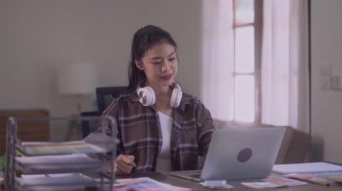 Young Asian Women Graphic Designer relaxing with stretching raised arms while taking break from work at her desk in creative office. High quality 4k footage