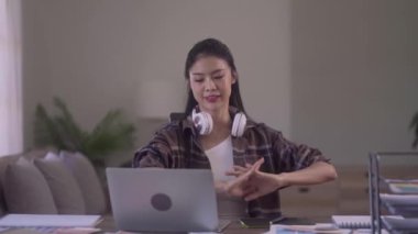 Young Asian Women Graphic Designer relaxing with stretching raised arms while taking break from work at her desk in creative office. High quality 4k footage