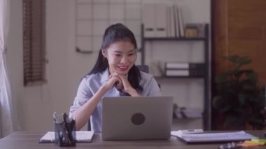 Young Asian business woman talking leading hybrid conference discussing project remote video call virtual meeting by using computer from home office. High quality 4k footage