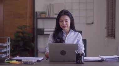 Elegant business Asian woman very happy cheering with clenched fists at office desk finish project work at her office. High quality 4k footage