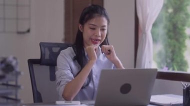 Young Asian business woman talking leading hybrid conference discussing project remote video call virtual meeting by using computer from home office. High quality 4k footage