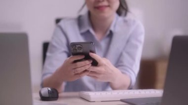 Güzel Asyalı girişimci iş kadını cep telefonu ya da akıllı telefon kullanarak evdeki oturma odasında çalışan cep telefonu teknolojisini kullanıyor. Yüksek kalite 4k görüntü