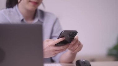 Güzel Asyalı girişimci iş kadını cep telefonu ya da akıllı telefon kullanarak evdeki oturma odasında çalışan cep telefonu teknolojisini kullanıyor. Yüksek kalite 4k görüntü