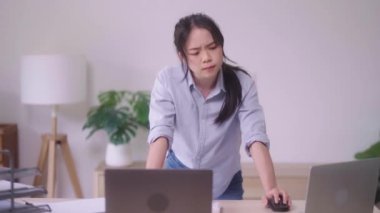 Evinde analitik çizelgeleri ve grafikleri olan dizüstü bilgisayarını kullanarak belgelerle uğraşan Asyalı genç bir kadın. Ev konsepti üzerine çalışıyor.. 
