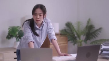 Evinde analitik çizelgeleri ve grafikleri olan dizüstü bilgisayarını kullanarak belgelerle uğraşan Asyalı genç bir kadın. Ev konsepti üzerine çalışıyor.. 