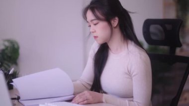 Dizüstü bilgisayarda çalışan uykulu yorgun genç Asyalı kadının gözleri kapanıyor ve evde ilgisiz bir şekilde uykuya dalmak üzere. Yüksek kalite 4k görüntü