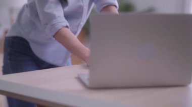 Evinde analitik çizelgeleri ve grafikleri olan dizüstü bilgisayarını kullanarak belgelerle uğraşan Asyalı genç bir kadın. Ev konsepti üzerine çalışıyor.. 