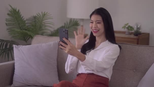 Smiling Young Attractive Asian Woman Using Smartphone Waving Hand Streaming — Stok Video