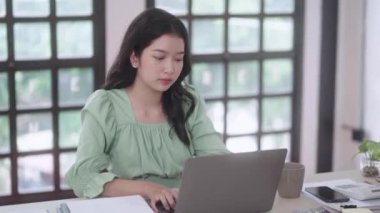 Genç Asyalı üniversite öğrencisi kadınlar evdeki oturma odasında dijital tabletle ve kulaklıkla e-öğrenim görüyorlar, uzaktan eğitim kavramı. Yüksek kalite 4k görüntü