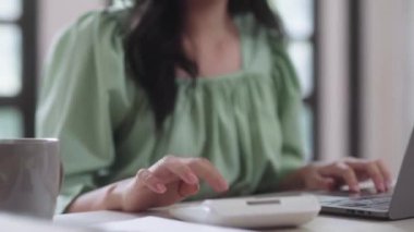 Genç Asyalı üniversite öğrencisi kadınlar evdeki oturma odasında dijital tabletle ve kulaklıkla e-öğrenim görüyorlar, uzaktan eğitim kavramı. Yüksek kalite 4k görüntü
