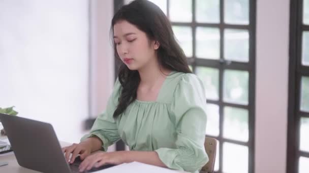 若いアジアの大学生の女性は 自宅のリビングルームでデジタルタブレットとヘッドフォンでオンラインレッスン電子ラーニング 遠隔教育コンセプト 高品質の4K映像 — ストック動画