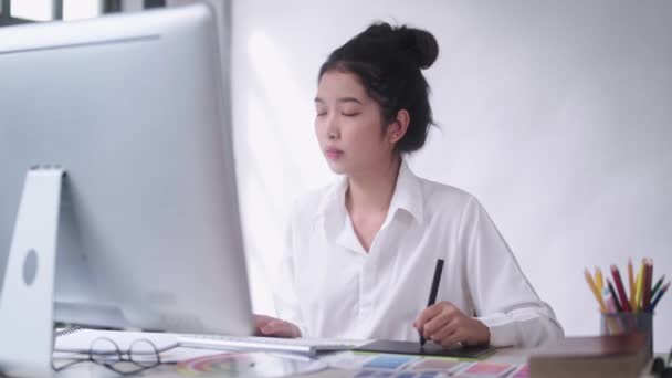 若いアジアの女性フリーランスのグラフィックデザイナーやアーティストのレトウチャー スタイラスペンでデジタルタブレットに描画 — ストック動画