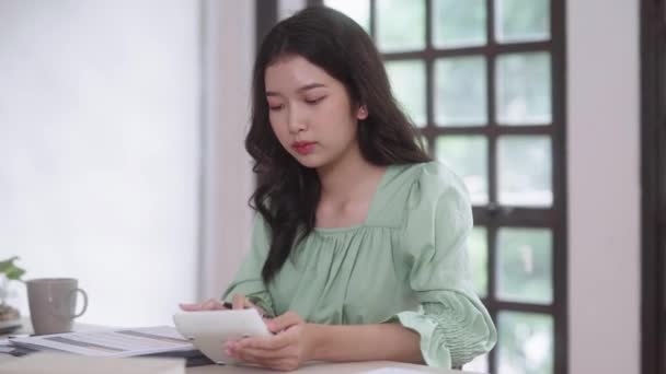 年轻的亚洲女大学生在家里客厅里用数字平板电脑和耳机在线学习 远程教育的概念 高质量的4K镜头 — 图库视频影像