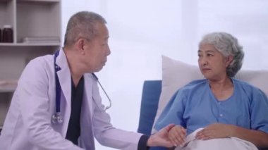 Uzman uzman kıdemli Asyalı doktor desteği emekli yaşlı kadınların avuçlarını tutmasını teşvik ediyor..