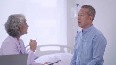 Kıdemli Asyalı Kadın Doktor, klinikteki sağlık kontrolü sırasında muayene odasında, sağlık hizmetlerinde ya da hastanede üst düzey bir erkek hastayla konuşuyor. Yüksek kalite 4k görüntü