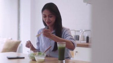 Sağlıklı Asyalı kadın evdeki mutfakta sebze salatası hazırlıyor. Vejetaryen gıda konsepti. Yüksek kalite 4k görüntü