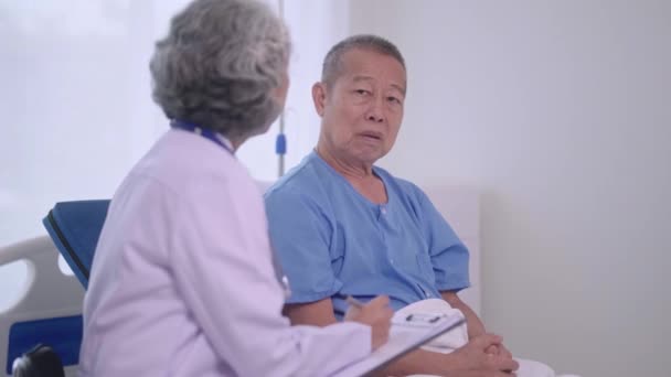 上級アジア女性医師は 検査室 病院でのサポートのシニア男性患者との診察で医療検査中に話しています 高品質の4K映像 — ストック動画