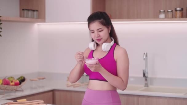 Sportowy Uśmiechnięta Młoda Azjatka Odzieży Sportowej Jedząc Zdrowe Śniadanie Jogurt — Wideo stockowe