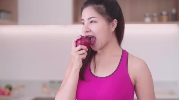 Sportliche Junge Asiatinnen Sportbekleidung Essen Apfel Der Küche Interieur Genießen — Stockvideo