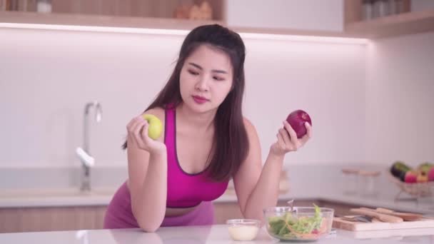 Sportliche Junge Asiatinnen Sportbekleidung Essen Apfel Der Küche Interieur Genießen — Stockvideo