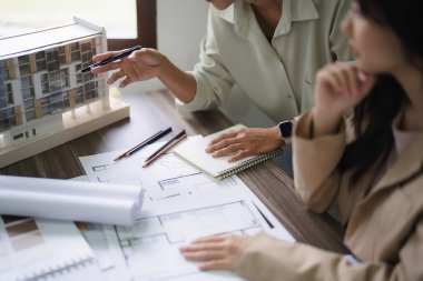 İki kadın mimar plandaki model ve iç tasarım hakkında tartışıyor ve beyin fırtınası yapıyor..