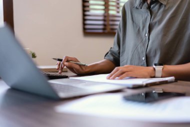 Günlük iş kadınları mali kağıt ve analiz pazarlama stratejisini kontrol etmek için hesap makinesi kullanıyor.