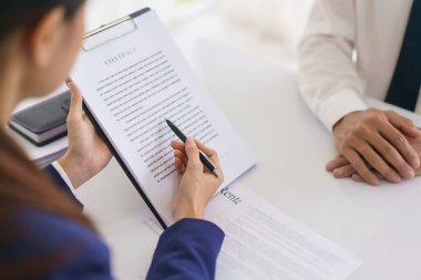 Avukat kadın iş sözleşmesini açıklıyor ve iş adamıyla hukuki danışmanlık anlaşması yapıyor..