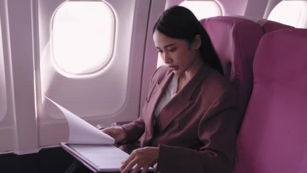 Azjatycka Bizneswoman Skrupulatnie Analizuje Swoje Dokumenty Biznesowe Podczas Podróży Samolotem — Wideo stockowe