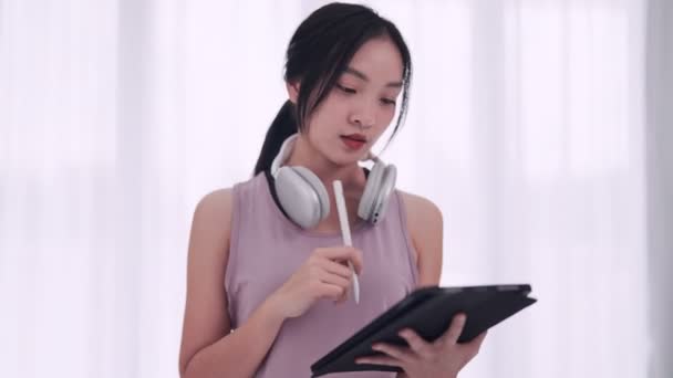 Asiatisk Kvinna Träningskläder Använder Tablett För Yogalektioner Matta Hennes Hem — Stockvideo