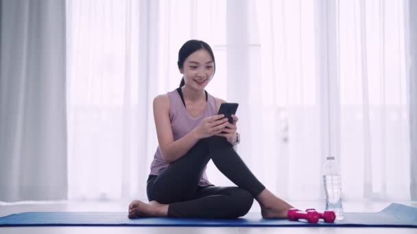 Asian Woman Workout Attire Using Smartphone Yoga Mat Her Homes — Stock Video