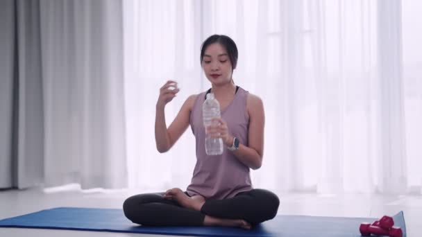 Азиатская Женщина Спортивном Костюме После Упражнений Коврике Гостиной Принимает Освежающий — стоковое видео