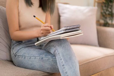 Yaratıcı tasarım konsepti, moda tasarımcısı kanepeye oturur ve yeni koleksiyon elbisesi yaratmak için çizim yapar..