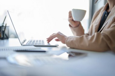 İş kadınları kahve içerken ve yeni başlatılan proje hakkında strateji ve yönetimi analiz etmek için çalışırken, iş yerlerindeki dijital dizüstü bilgisayarda yatırım ve iş dünyasının finansmanı hakkında rapor yazıyorlar..