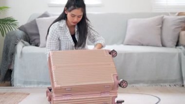 Asyalı kadın eşyalarını dikkatlice seyahat çantasına koyar. Uzun bir hafta sonu için maceralı bir yolculuğa hazırdır. Yüksek kalite 4k görüntü
