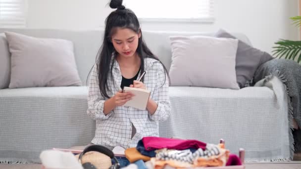 Aziatische Vrouw Met Behulp Van Een Notebook Haar Checklist Verpakking — Stockvideo