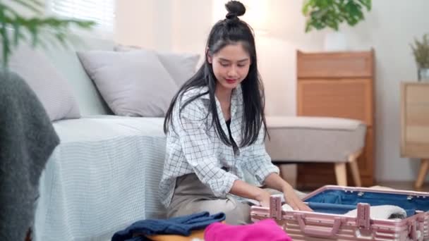 アジアの女性は彼女の持ち物を整理し 旅行バッグにそれらを詰め 休日の冒険の準備をする 高品質の4K映像 — ストック動画