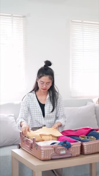 Asiatisk Kvinna Packar Effektivt Och Säkrar Sin Väska Med Remmar — Stockvideo